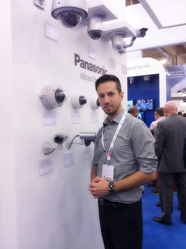Auf der Sicherheitsmesse 2012 vor einer Wand mit Überwachungskameras